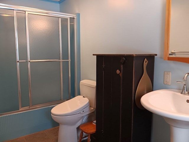 full bathroom featuring tile patterned floors, sink, enclosed tub / shower combo, and toilet