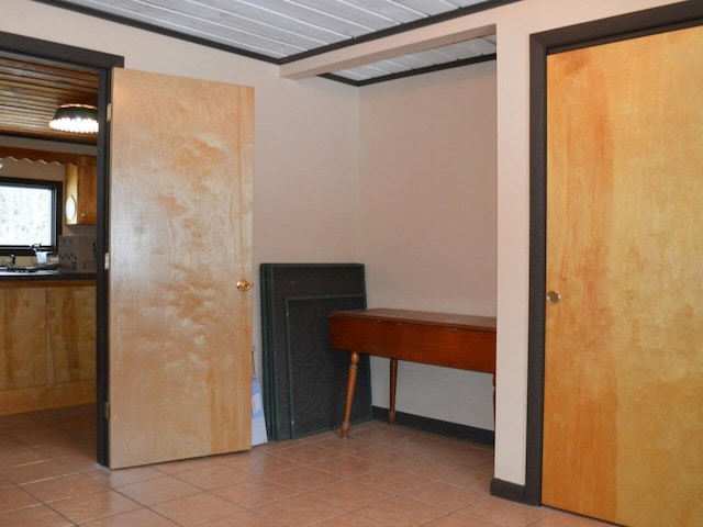 interior space featuring beamed ceiling and light tile patterned flooring