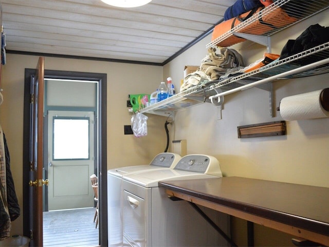 laundry area featuring hardwood / wood-style flooring, washer and clothes dryer, and ornamental molding