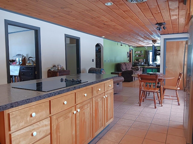 kitchen with light brown cabinetry, black electric stovetop, light tile patterned flooring, and wooden ceiling