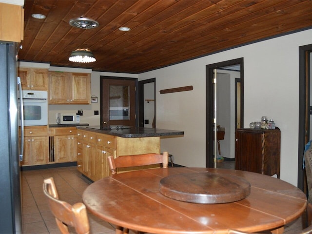 kitchen featuring light tile patterned floors, wood ceiling, and white appliances