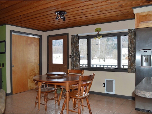 tiled dining area featuring wood ceiling and an inviting chandelier