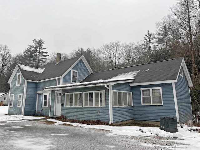 view of snow covered back of property