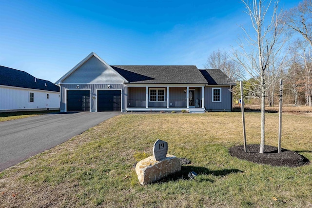 ranch-style house featuring a front lawn, covered porch, and a garage