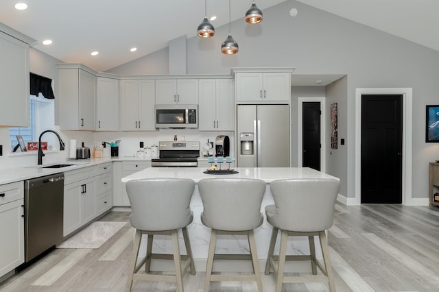 19 Whippoorwill Way, Somersworth, NH 03878 - kitchen featuring appliances with stainless steel finishes, light wood-type flooring, light countertops, hanging light fixtures, and high vaulted ceiling