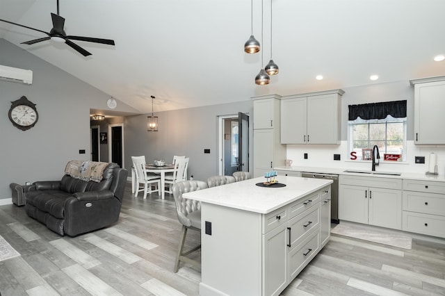 19 Whippoorwill Way, Somersworth, NH 03878 - kitchen featuring stainless steel dishwasher, a breakfast bar area, open floor plan, a wall mounted AC, and light countertops