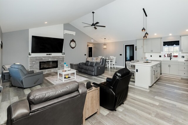 19 Whippoorwill Way, Somersworth, NH 03878 - living area with light wood-style floors, ceiling fan, vaulted ceiling, a stone fireplace, and recessed lighting