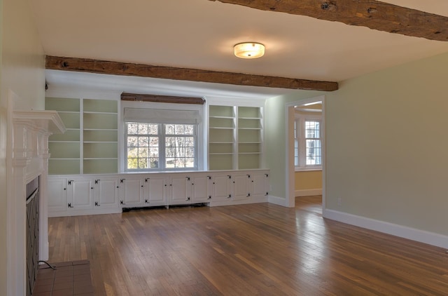 unfurnished room with beamed ceiling and hardwood / wood-style flooring