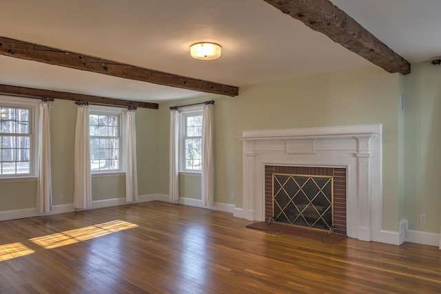 unfurnished living room featuring a fireplace, beam ceiling, and dark wood-type flooring