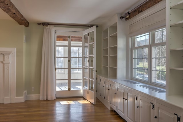 doorway featuring a wealth of natural light, beamed ceiling, and light wood-type flooring