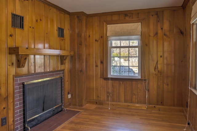 living room featuring a fireplace, wood-type flooring, and wooden walls