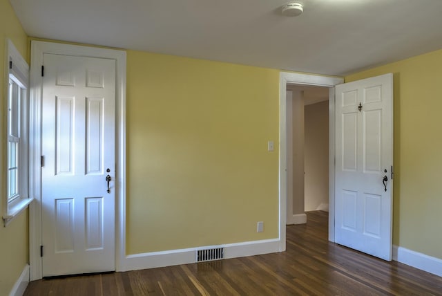 unfurnished bedroom featuring dark hardwood / wood-style flooring