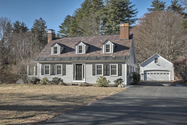 cape cod home featuring a garage and an outbuilding