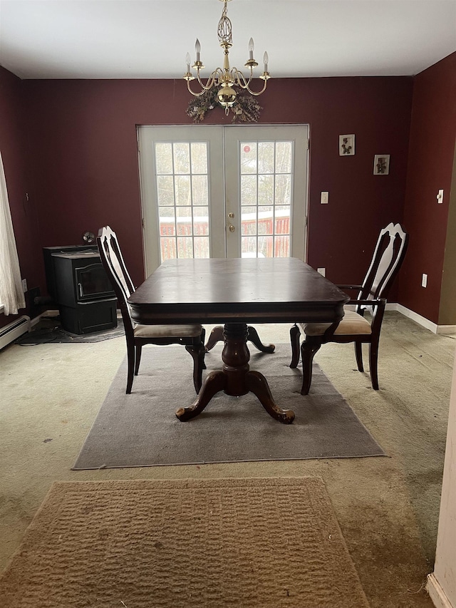 dining area featuring a notable chandelier, carpet floors, and french doors