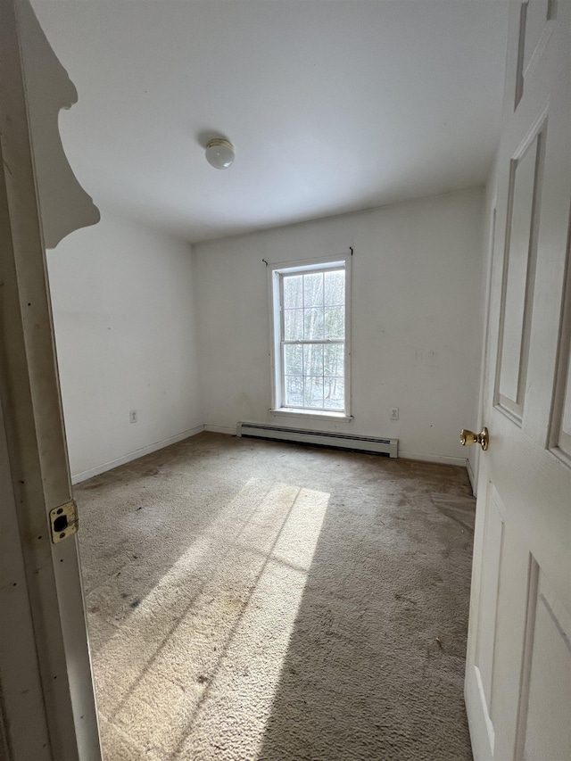 carpeted spare room with a baseboard radiator