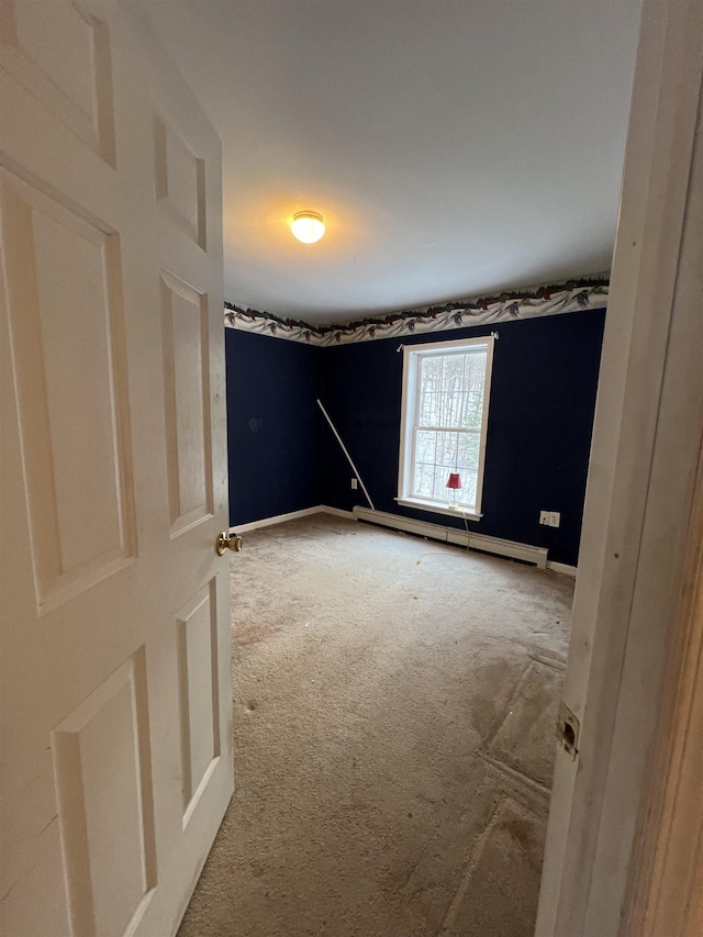 carpeted spare room featuring a baseboard radiator