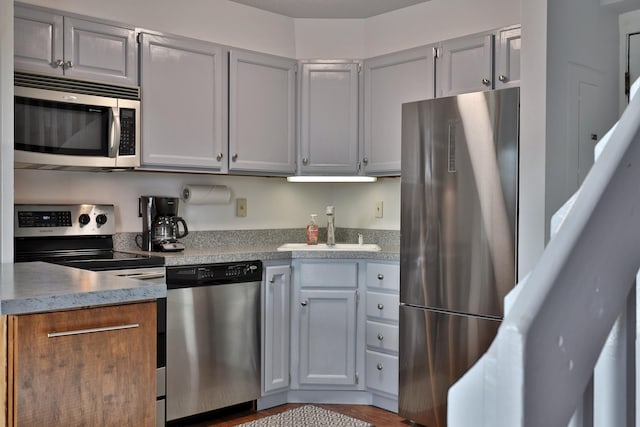 kitchen featuring gray cabinetry, light wood-type flooring, sink, and appliances with stainless steel finishes