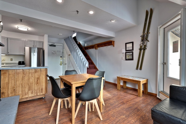 dining area featuring dark hardwood / wood-style flooring and a textured ceiling