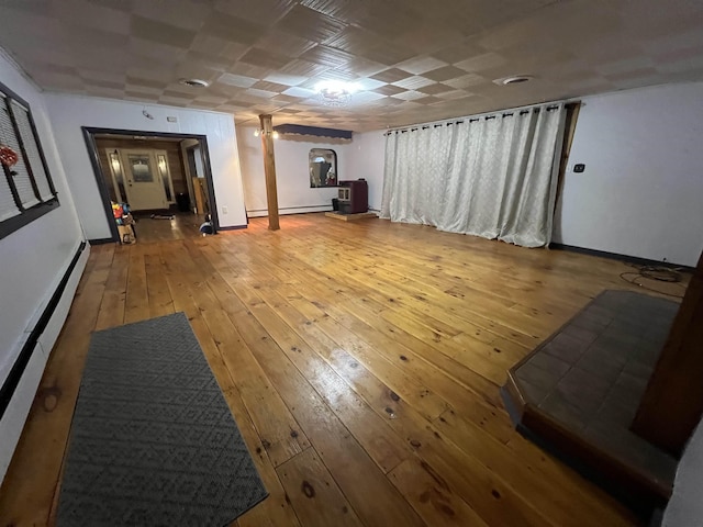 basement with a baseboard radiator and light hardwood / wood-style floors