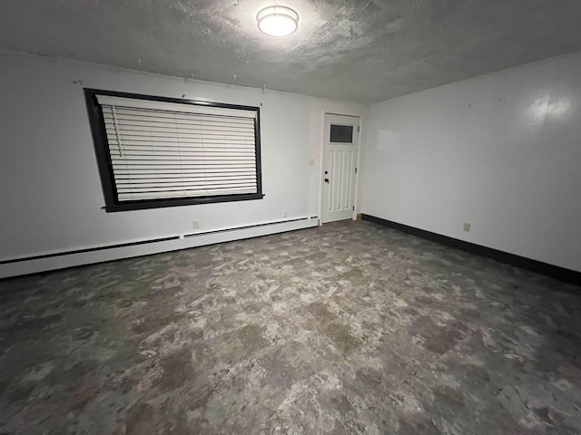 spare room with a textured ceiling and baseboard heating