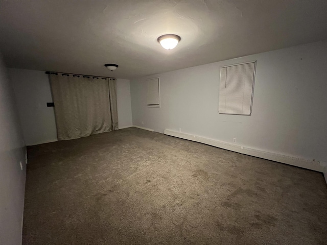 unfurnished room featuring baseboard heating and carpet