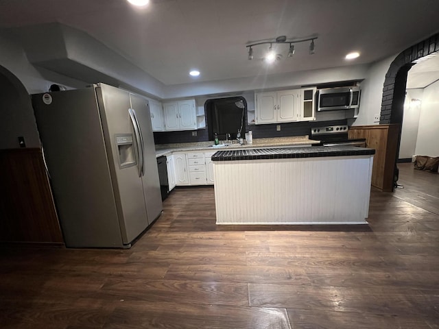 kitchen featuring appliances with stainless steel finishes, dark hardwood / wood-style flooring, and white cabinets