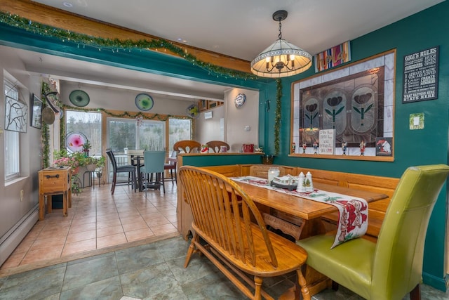 dining area with a baseboard heating unit, an inviting chandelier, beamed ceiling, and plenty of natural light