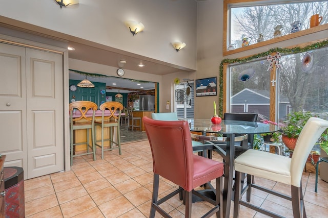 tiled dining area with a towering ceiling