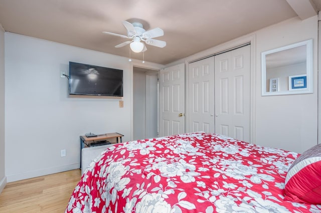 bedroom with ceiling fan, light hardwood / wood-style floors, and a closet