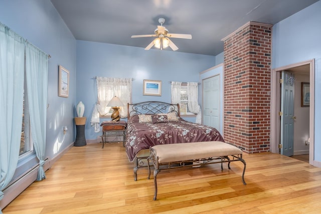 bedroom featuring a baseboard radiator, a closet, ceiling fan, and light hardwood / wood-style flooring