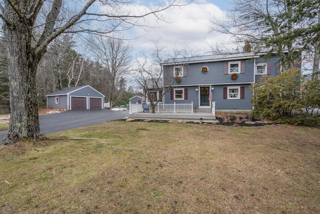 view of front facade with a front yard, a garage, and an outdoor structure