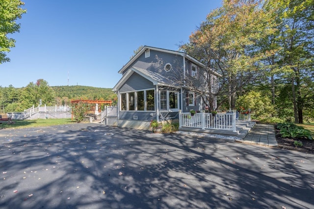 view of front of house with a wooden deck and a sunroom