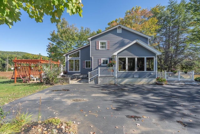 back of property featuring a pergola, a patio, and a sunroom