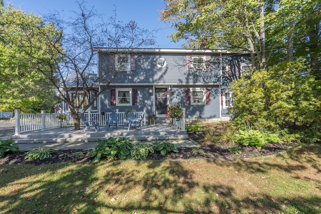 back of property with a lawn and a wooden deck