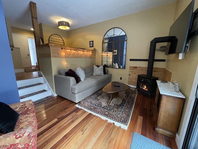 living room with a textured ceiling, a wood stove, and dark hardwood / wood-style floors