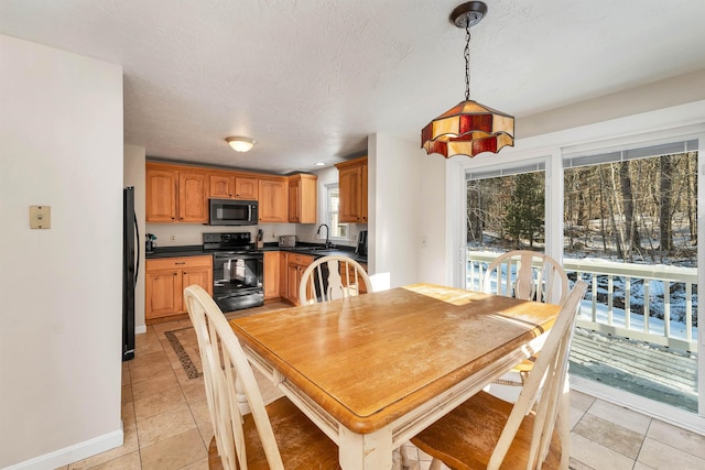 dining room featuring a textured ceiling, light tile patterned floors, and sink