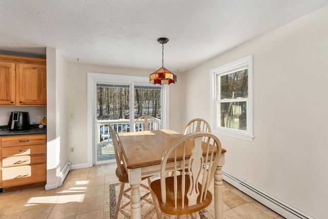 dining space with a healthy amount of sunlight, a textured ceiling, and a baseboard radiator