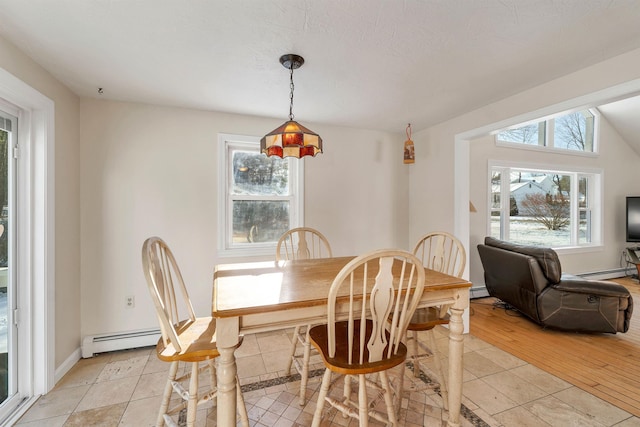 dining room featuring a textured ceiling, lofted ceiling, a baseboard radiator, and light hardwood / wood-style floors