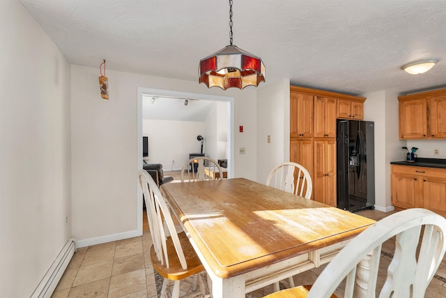 tiled dining space featuring a textured ceiling and baseboard heating