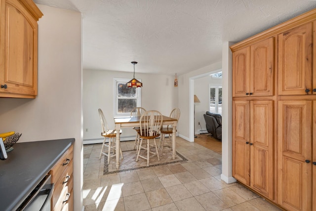 dining space with light tile patterned floors, a textured ceiling, and a baseboard heating unit