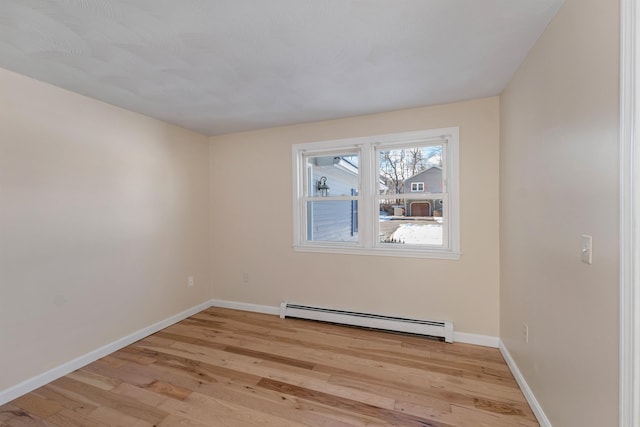 empty room with light wood-type flooring and a baseboard radiator