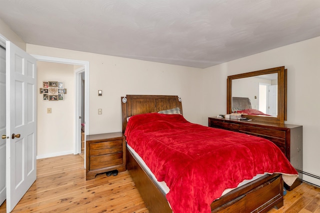 bedroom featuring light hardwood / wood-style flooring and baseboard heating