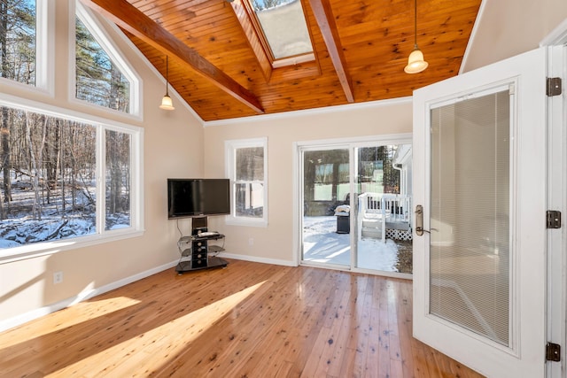 exercise area with hardwood / wood-style floors, plenty of natural light, and lofted ceiling with skylight