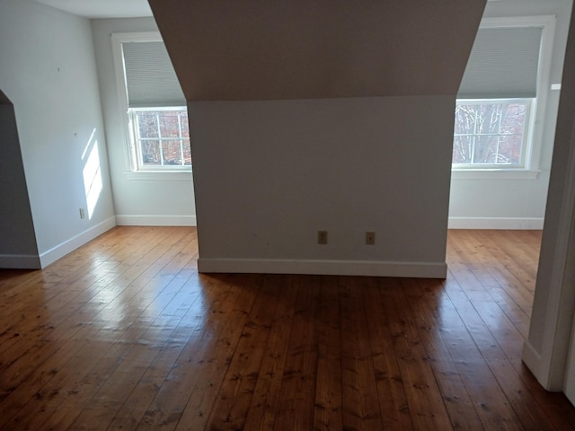 additional living space with hardwood / wood-style flooring and lofted ceiling