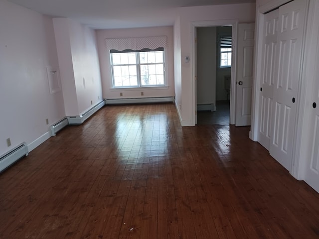 spare room with dark hardwood / wood-style flooring and baseboard heating