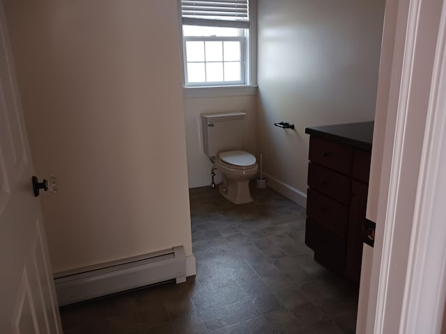 bathroom featuring vanity, toilet, and baseboard heating