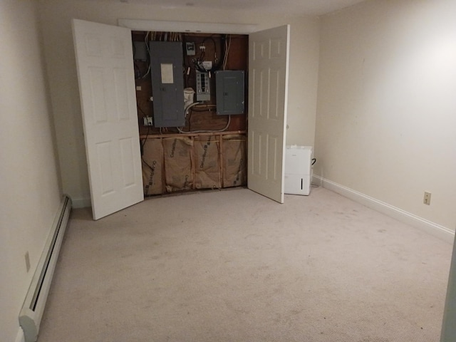 carpeted spare room featuring electric panel and a baseboard radiator