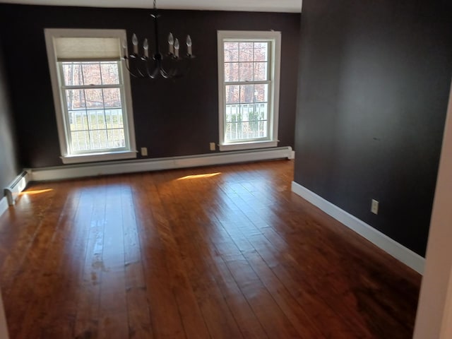 unfurnished dining area with dark hardwood / wood-style flooring, plenty of natural light, a baseboard radiator, and a notable chandelier