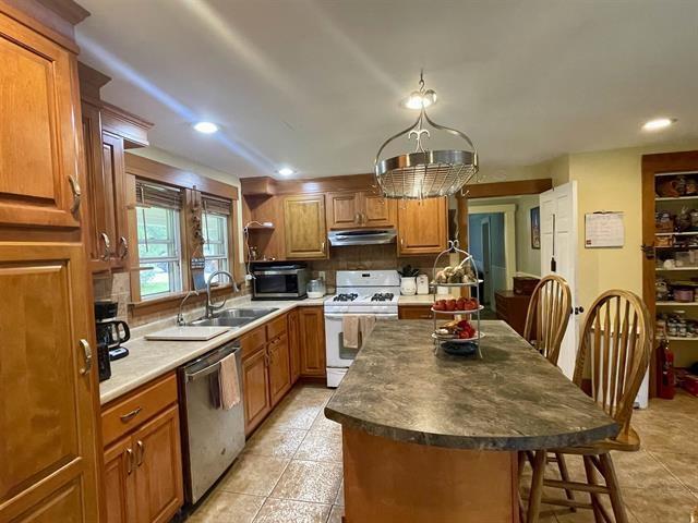 kitchen with a center island, backsplash, sink, a breakfast bar area, and stainless steel appliances