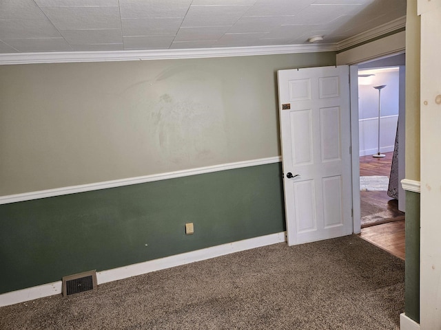 carpeted spare room featuring crown molding